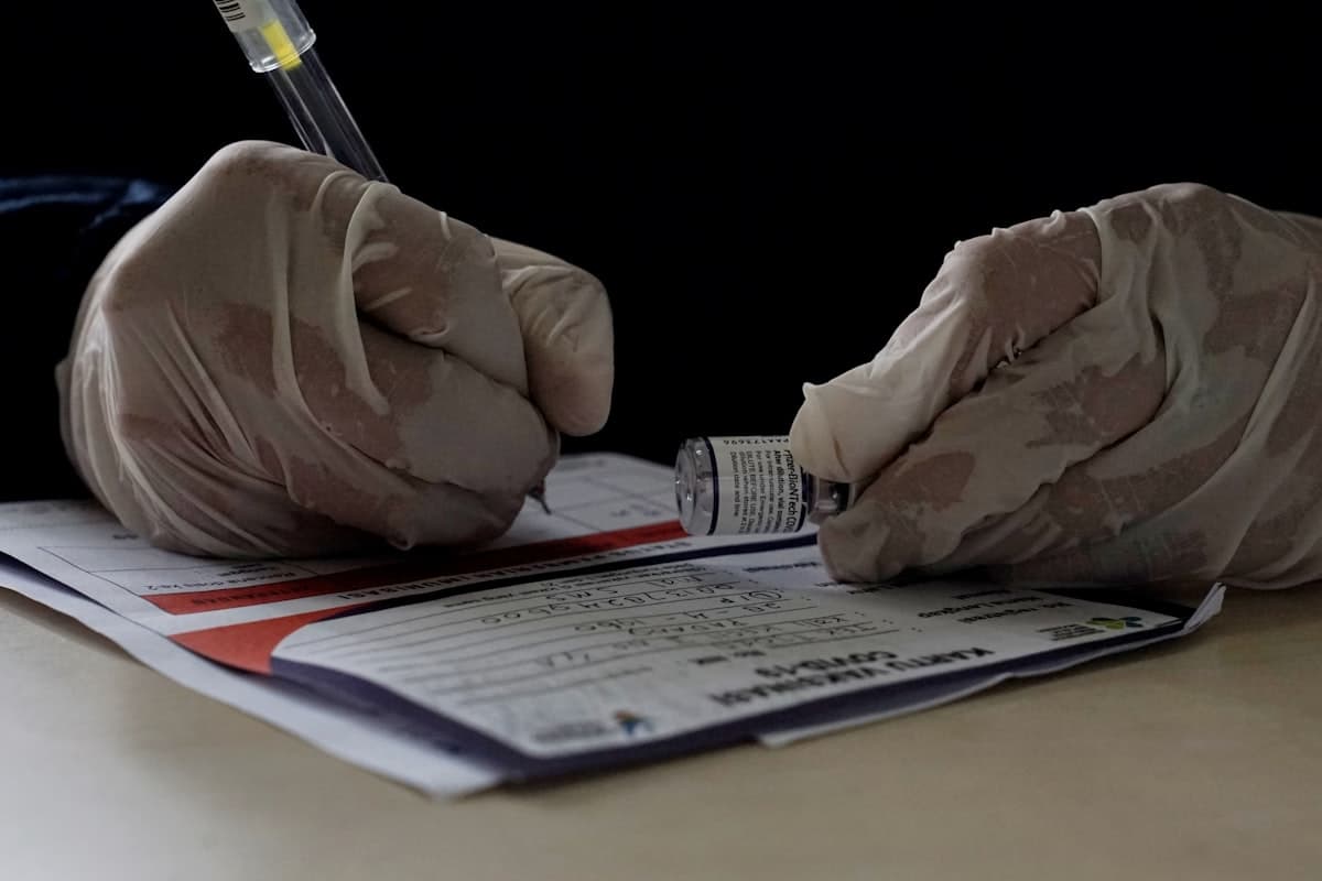 Mâini în mănuși completând un formular medical